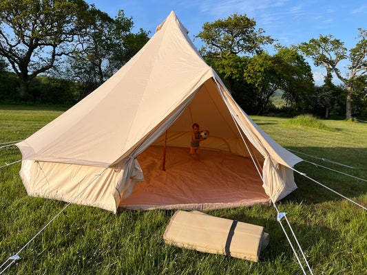 New 5m Bell Tent with open door. Polypropylene matting laying on grass outside.